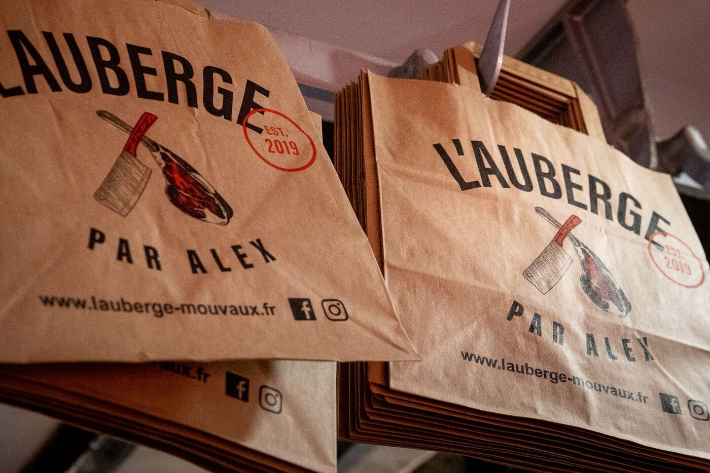 Les sacs en papier kraft de L'Auberge de Mouvaux, avec le couperet et la côte de bœuf